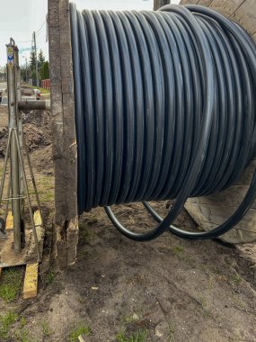 Bir yeraltı elektrik ağı inşa edilirken büyük bir varilin üzerinde kablo..