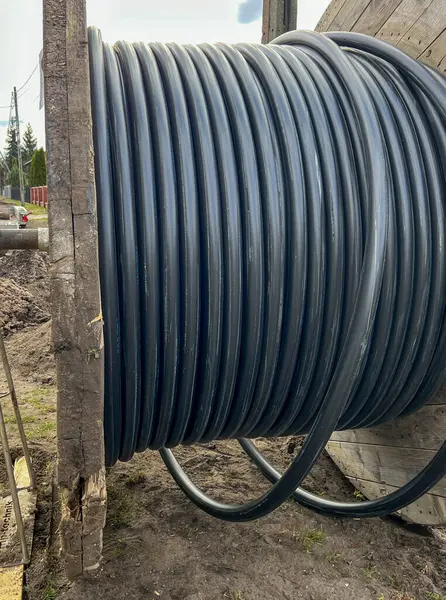 Bir yeraltı elektrik ağı inşa edilirken büyük bir varilin üzerinde kablo..