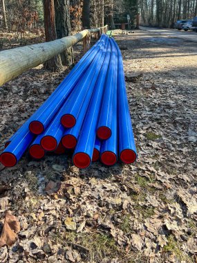 Ormanın otoparkında saklanan kırmızı başlıklı mavi plastik borular yere gömülmeye hazır..