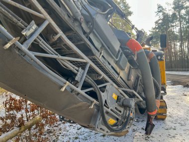 Bir otoparkta asfalt değirmen makinesi, kanalizasyon sistemi inşa edilirken yol yüzeyinin bir kısmını kaldırmayı bekliyor..