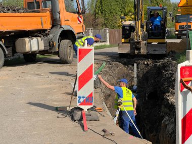 Kalety, Polonya, 24 Nisan 2025: Kırsal alanda bir kanalizasyon sistemi inşa edilmesi. Kırsala, yolun altına boru döşüyorlar..