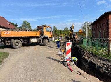 Kalety, Polonya, 24 Nisan 2025: Kırsal alanda bir kanalizasyon sistemi inşa edilmesi. Kırsala, yolun altına boru döşüyorlar..