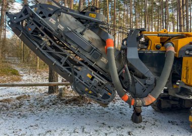 Bir otoparkta asfalt değirmen makinesi, kanalizasyon sistemi inşa edilirken yol yüzeyinin bir kısmını kaldırmayı bekliyor..