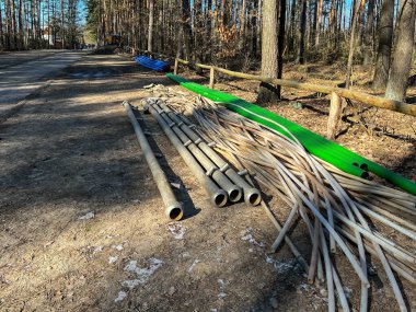 Bir kanalizasyon sistemi inşa edilirken orman yolu boyunca uzanan çeşitli borular: toprağı kurutmak, iğne filtreleri, kanalizasyon ve su için plastik ve diğerleri için kullanılan koleksiyoncular.