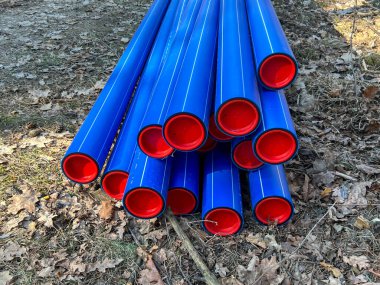 Ormanın otoparkında saklanan kırmızı başlıklı mavi plastik borular yere gömülmeye hazır..