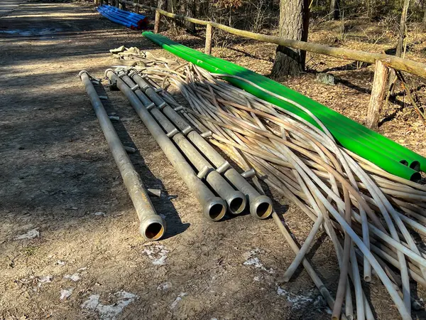 Bir kanalizasyon sistemi inşa edilirken orman yolu boyunca uzanan çeşitli borular: toprağı kurutmak, iğne filtreleri, kanalizasyon ve su için plastik ve diğerleri için kullanılan koleksiyoncular.