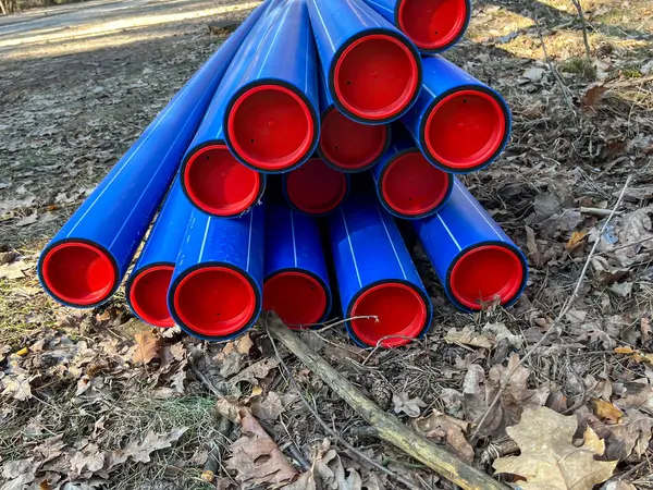 Ormanın otoparkında saklanan kırmızı başlıklı mavi plastik borular yere gömülmeye hazır..