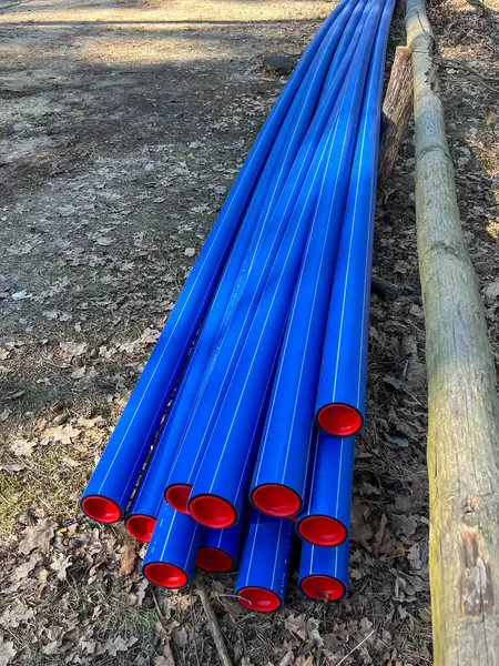 Ormanın otoparkında saklanan kırmızı başlıklı mavi plastik borular yere gömülmeye hazır..