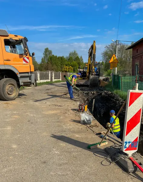 Kalety, Polonya, 24 Nisan 2025: Kırsal alanda bir kanalizasyon sistemi inşa edilmesi. Kırsala, yolun altına boru döşüyorlar..