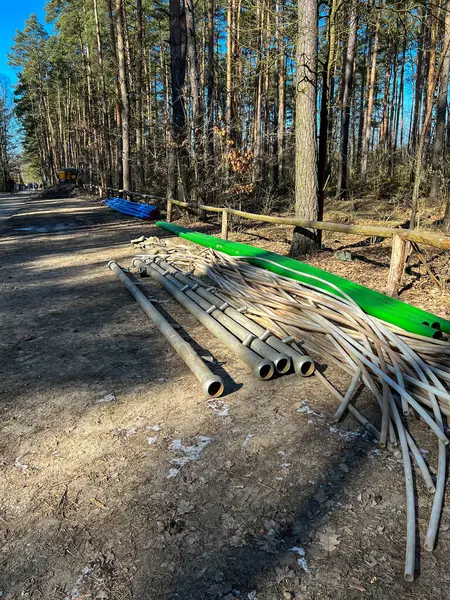 Bir kanalizasyon sistemi inşa edilirken orman yolu boyunca uzanan çeşitli borular: toprağı kurutmak, iğne filtreleri, kanalizasyon ve su için plastik ve diğerleri için kullanılan koleksiyoncular.