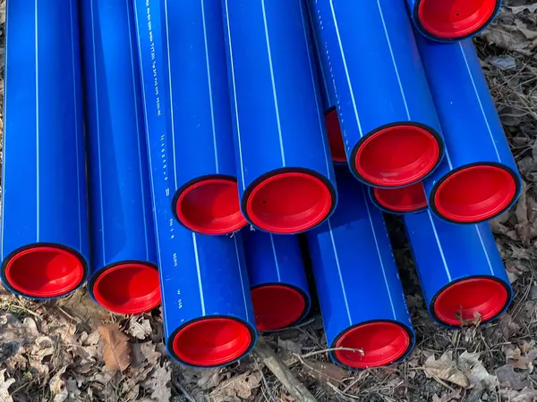 Ormanın otoparkında saklanan kırmızı başlıklı mavi plastik borular yere gömülmeye hazır..