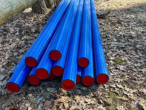 Ormanın otoparkında saklanan kırmızı başlıklı mavi plastik borular yere gömülmeye hazır..