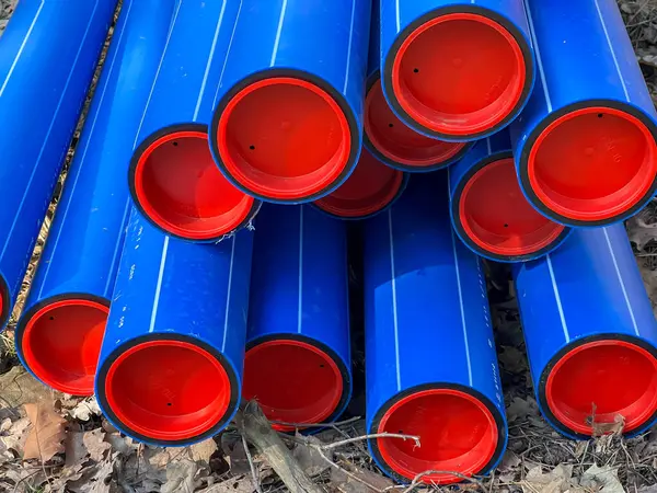 Ormanın otoparkında saklanan kırmızı başlıklı mavi plastik borular yere gömülmeye hazır..