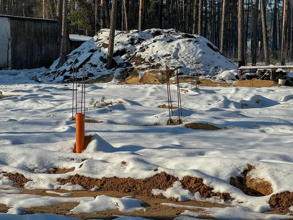 Kışın ağaçların arasında, karla kaplı tamamlanmış tek bir aile inşaat sahası..