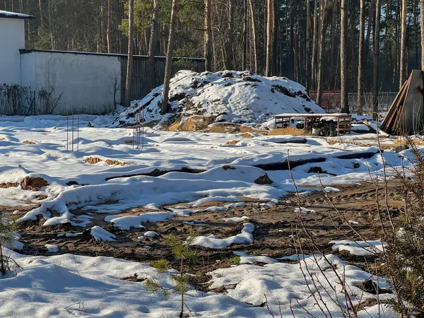 Kışın ağaçların arasında, karla kaplı tamamlanmış tek bir aile inşaat sahası..