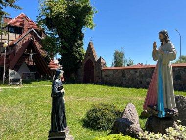 Merhametli İsa ve Aziz Rahibe Faustina 'nın figürü, Polonya' nın Batı Pomeranya Voyvoda Mysliborz 'daki Kutsal Merhamet Tapınağı' nın bahçesinde..