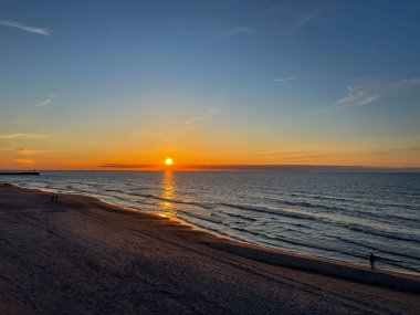 Polonya 'nın Mrzezyno bölgesindeki Baltık Denizi' nde mayıs ayında plajda gün batımı.