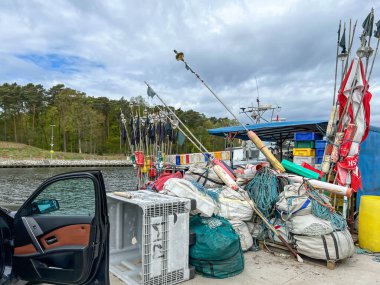 Mrzezyno, Polonya, 8 Mayıs 2025: Baltık Denizi 'ndeki Mrzezyno limanına yanaşan balıkçı teknelerine binmek için ağ ve çeşitli ekipman ve bavullar hazırlandı.
