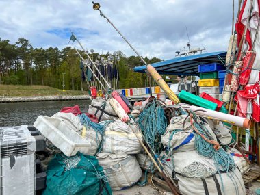 Mrzezyno, Polonya, 8 Mayıs 2025: Baltık Denizi 'ndeki Mrzezyno limanına yanaşan balıkçı teknelerine binmek için ağ ve çeşitli ekipman ve bavullar hazırlandı.
