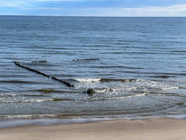Polonya 'nın Mrzezyno bölgesindeki boş Baltık plajları. Mandallardan yapılmış karakteristik dalgakıranlar..