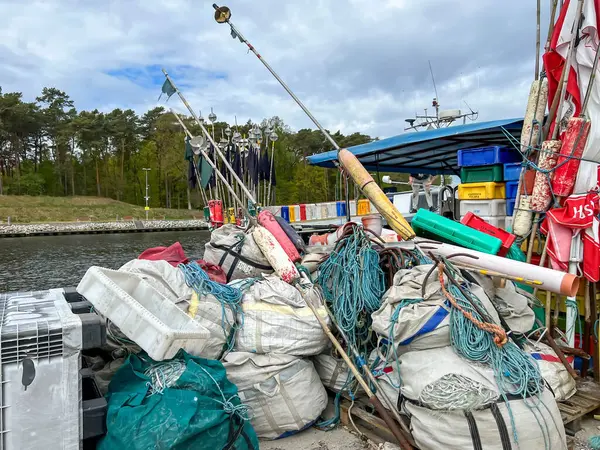 Mrzezyno, Polonya, 8 Mayıs 2025: Baltık Denizi 'ndeki Mrzezyno limanına yanaşan balıkçı teknelerine binmek için ağ ve çeşitli ekipman ve bavullar hazırlandı.