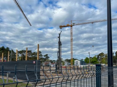 Polonya 'nın Mrzezyno şehrinde Baltık Denizi' nde bir apartman inşaatı için bir vinç ve yerde delik açmak için bir makine (büyük bir matkap).).