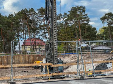 Polonya 'nın Mrzezyno şehrinde Baltık Denizi' nde bir apartman inşaatı için bir vinç ve yerde delik açmak için bir makine (büyük bir matkap).).