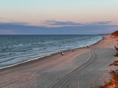 May, Mrzezyno, Polonya 'da neredeyse boş bir Baltık Denizi sahilinde yürüyor..