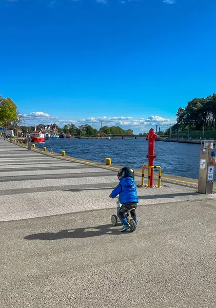 Kask takan küçük bir çocuk Mrzezyno 'daki iskelede bisiklet sürüyor, Baltık Denizi' nde, Polonya 'da.