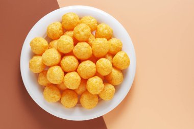 İki renkli arka planda izole edilmiş tabakta peynirli puf toplarının üst görüntüsü. Boşluğu kopyala