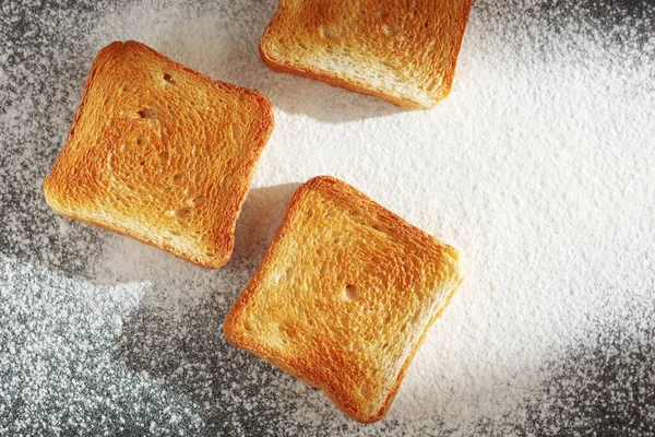 小麦粉の背景に小さなトーストパンのスライス トップビュー — ストック写真