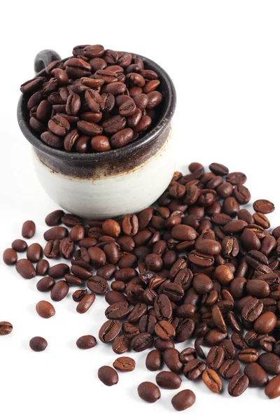 焙煎したコーヒー豆をカップに入れ 白い背景の近くに散乱 — ストック写真