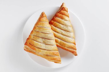 Beyaz arka planda bir tabakta elma üçgenleri tüttürmek, üst görünüm