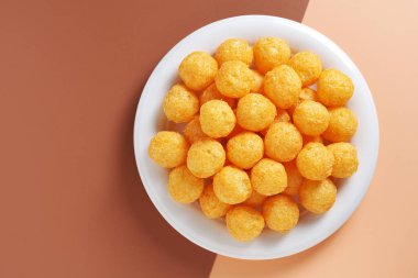 İki renkli arka planda izole edilmiş tabakta peynirli puf toplarının üst görüntüsü. Boşluğu kopyala