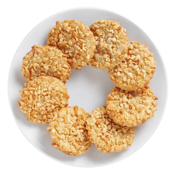 Biscuits with peanuts on a plate isolated on white background, top view 