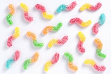 Colorful gummy jelly worm candies on white background, top view