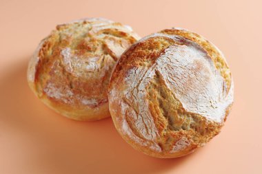 Loaves of small bread with potato flakes on color background close-up