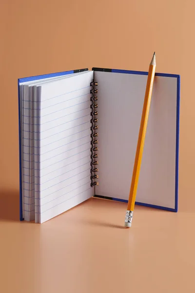 茶色の背景のメモ帳と鉛筆 — ストック写真