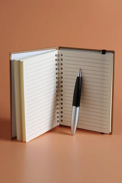 メモ帳とペンの茶色の背景 — ストック写真