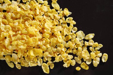 Siyah metal tepsi üzerinde mısır gevreği yığını, üst görünüm