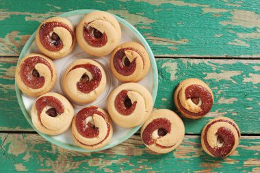 Eski yeşil ahşap arka planda reçelli kurabiyeler, üst manzara. 