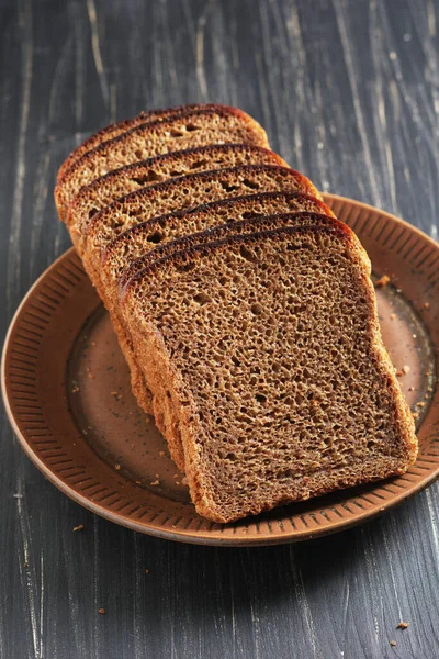 Κομμένο Ψωμί Σίκαλης Πιάτο Μαύρο Ξύλινο Φόντο — Φωτογραφία Αρχείου