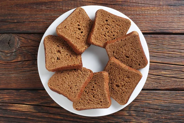 Potongan Roti Gandum Kecil Atas Piring Pada Latar Belakang Kayu — Stok Foto