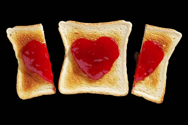 烤面包和两片半吐司与心脏形状果酱隔离在黑色背景 顶部视图 — 图库照片