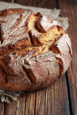 Rustik ahşap masa üzerinde çavdar ekmeği yakın plan.