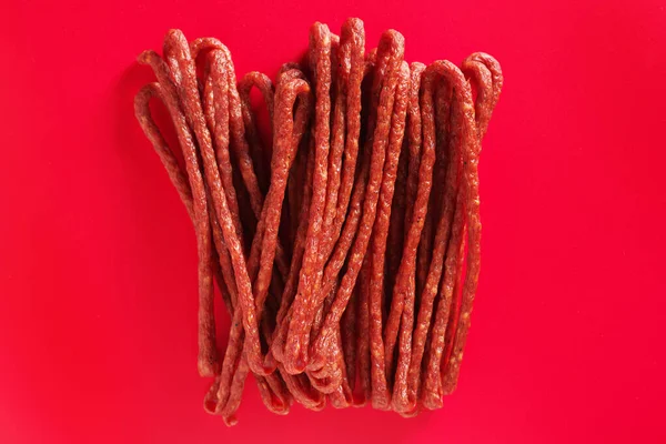 Thin Dry Smoke Polish Sausage Kabanos Auf Rotem Hintergrund Draufsicht — Stockfoto