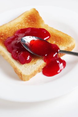 Beyaz arka planda reçelli kızarmış ekmek.