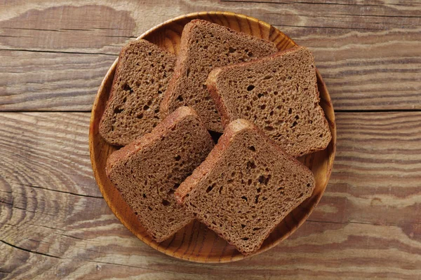 Plátky Malého Žitného Chleba Dřevěném Talíři Rustikálním Stole Pohled Shora — Stock fotografie