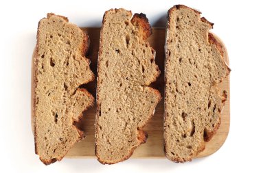 Beyaz arka planda kesme tahtasında çavdar ekmeği dilimleri, üst görünüm