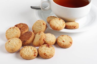 Marmelatlı kurabiyeler ve beyaz arka planda bir fincan çay.